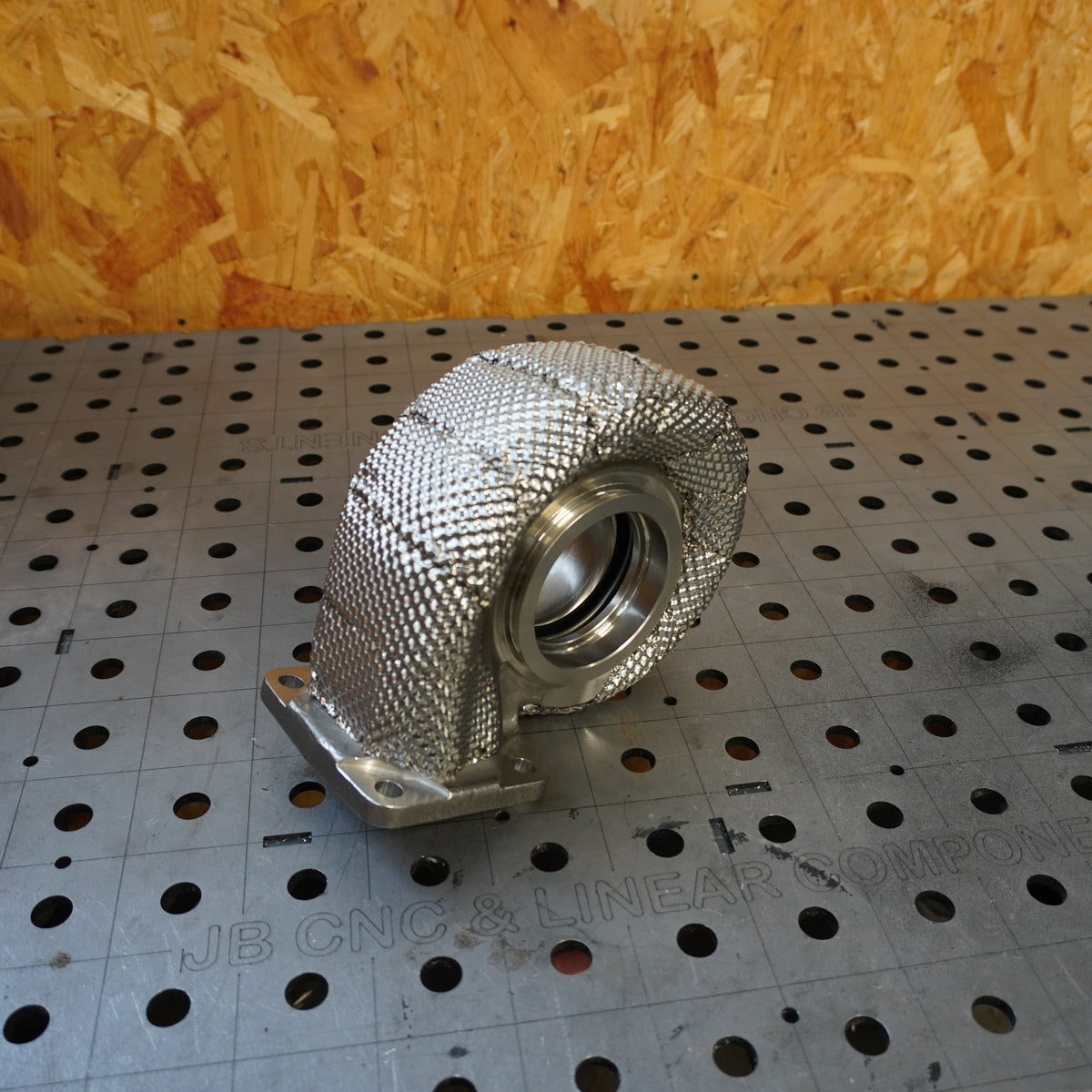 MLKR heat-shielded BMW exhaust manifold on a fabrication table